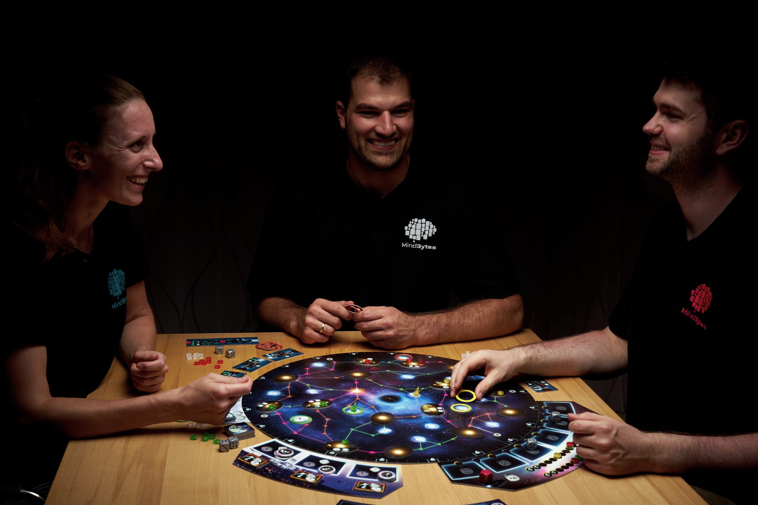 MindBytes sitzen am Tisch und spielen ein Strategiespiel